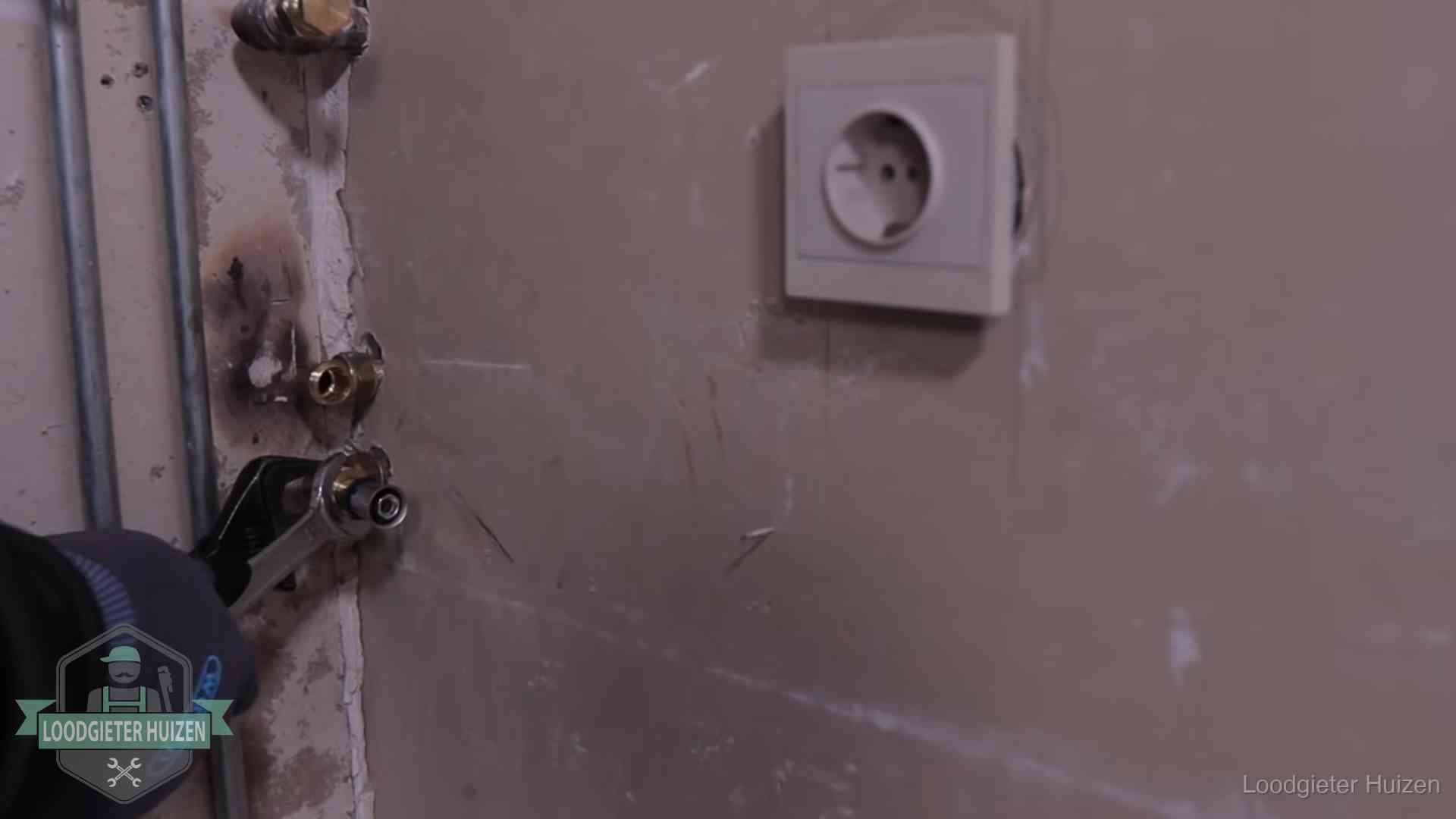 Erkend vakmanschap in Huizen Monteur draait een perskoppeling vast op een leidingaansluiting in Huizen