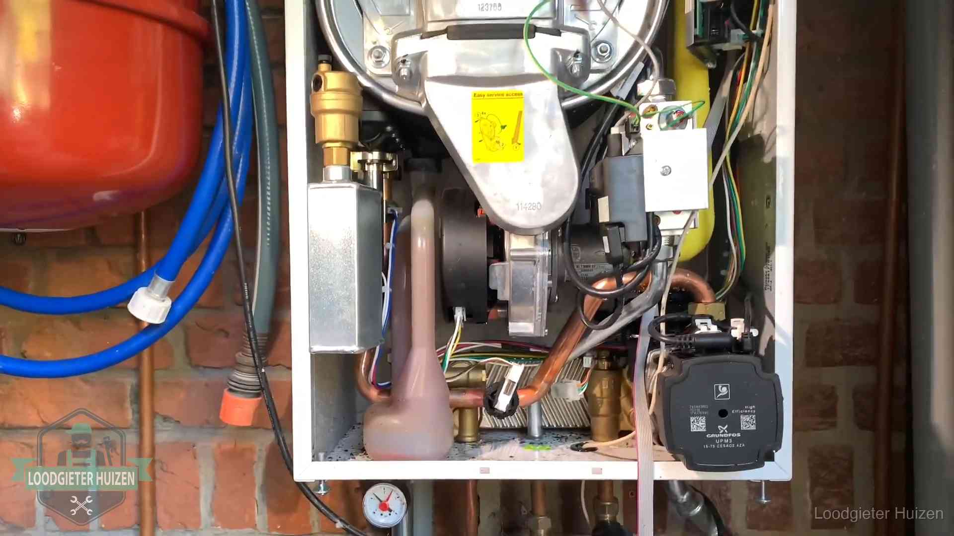 Expansievat en waterdruk in Huizen Geopende cv-ketel met rood expansievat in een woning in Huizen