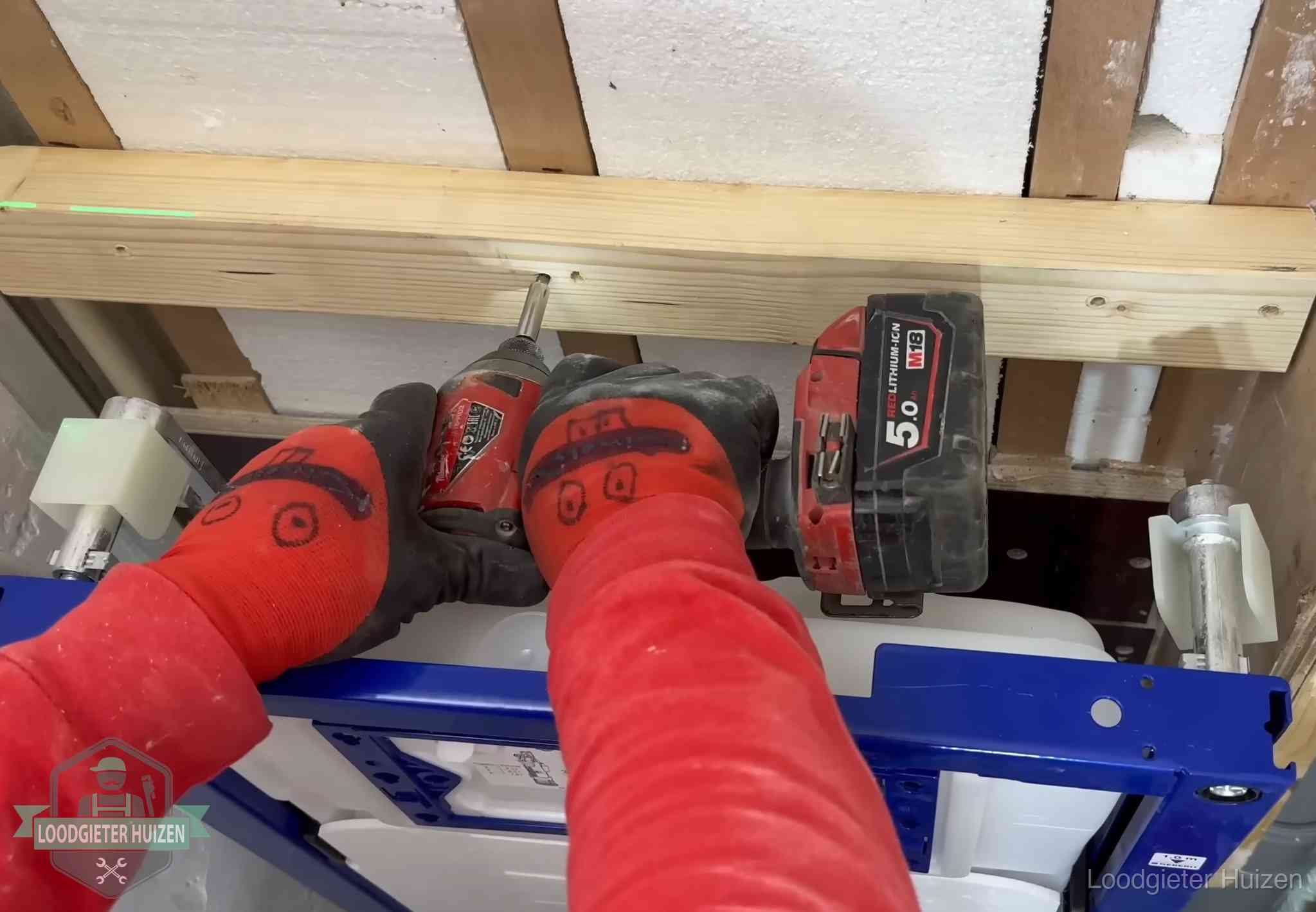 Fout in de wc-installatie opsporen in Huizen Monteur bevestigt een inbouwreservoir voor een hangend toilet in Huizen
