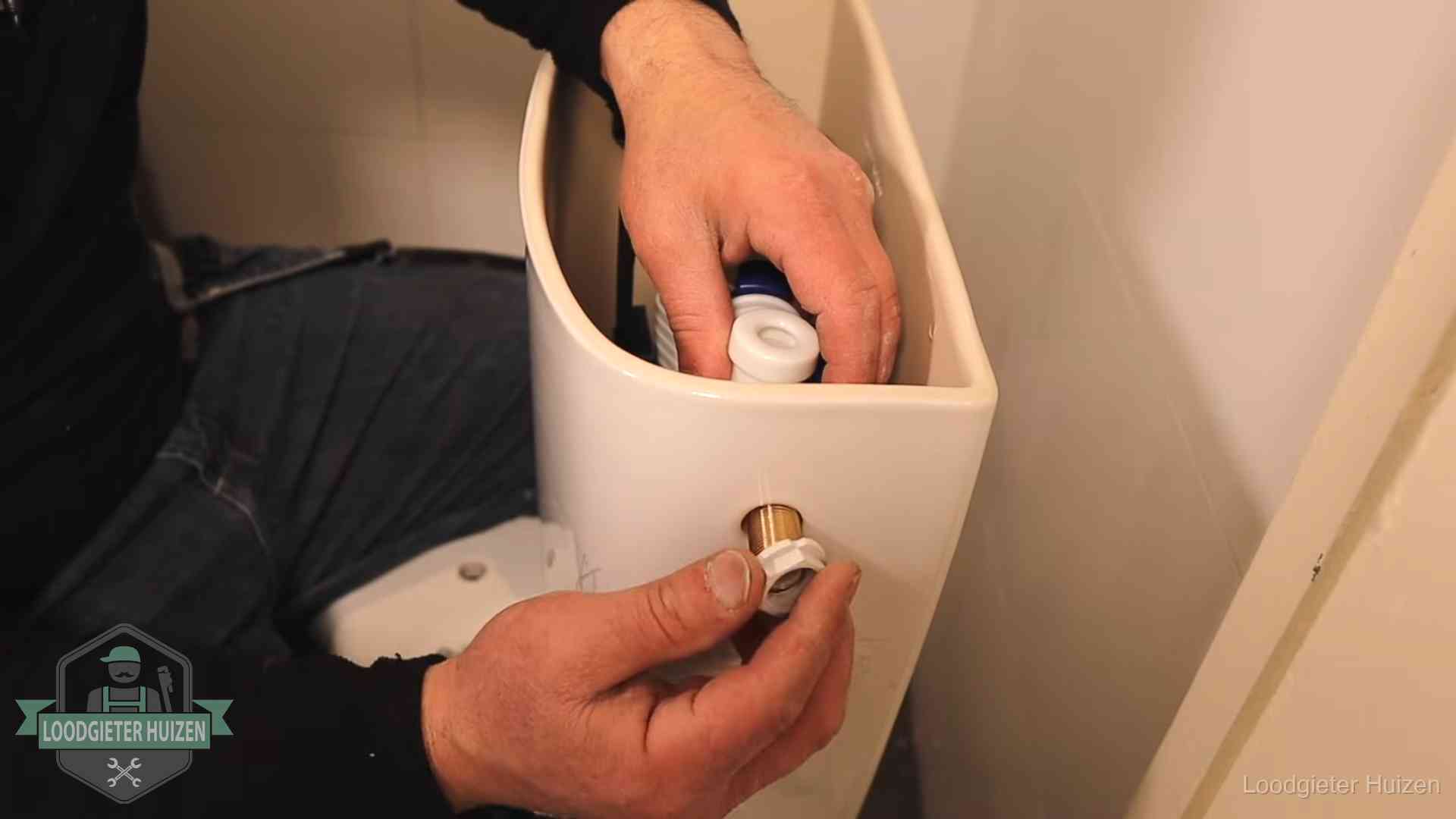 Loodgieter voor je verstopte wc in Huizen Loodgieter monteert de vlotterkraan van een stortbak bij een toilet in Huizen