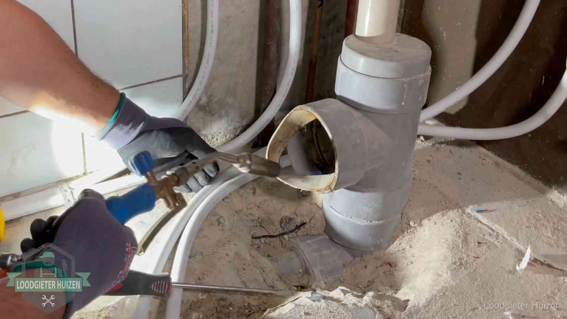 Vakmanschap van onze loodgieters in Huizen Loodgieter werkt met brander en messing kraanwerk aan leidingen in Huizen
