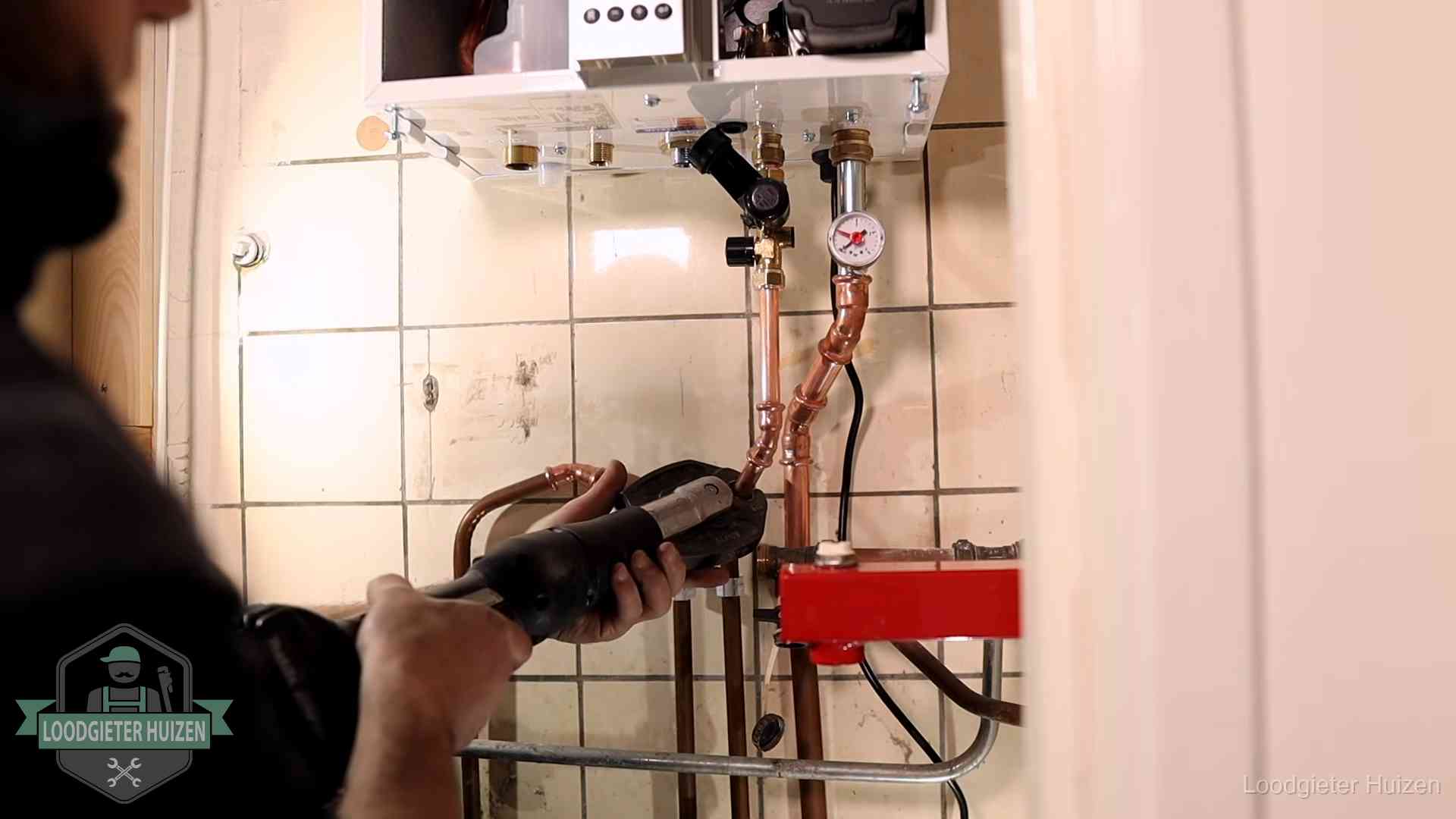 Cv-ketel onderhoud in Huizen Monteur werkt aan de leidingen onder een cv-ketel in Huizen