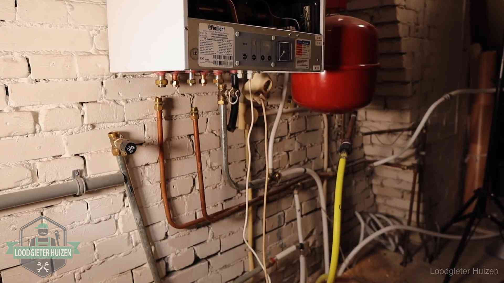 Onderhoud aan een oudere cv-ketel in Huizen Verouderde cv-ketel met een wirwar van oude leidingen in een woning in Huizen