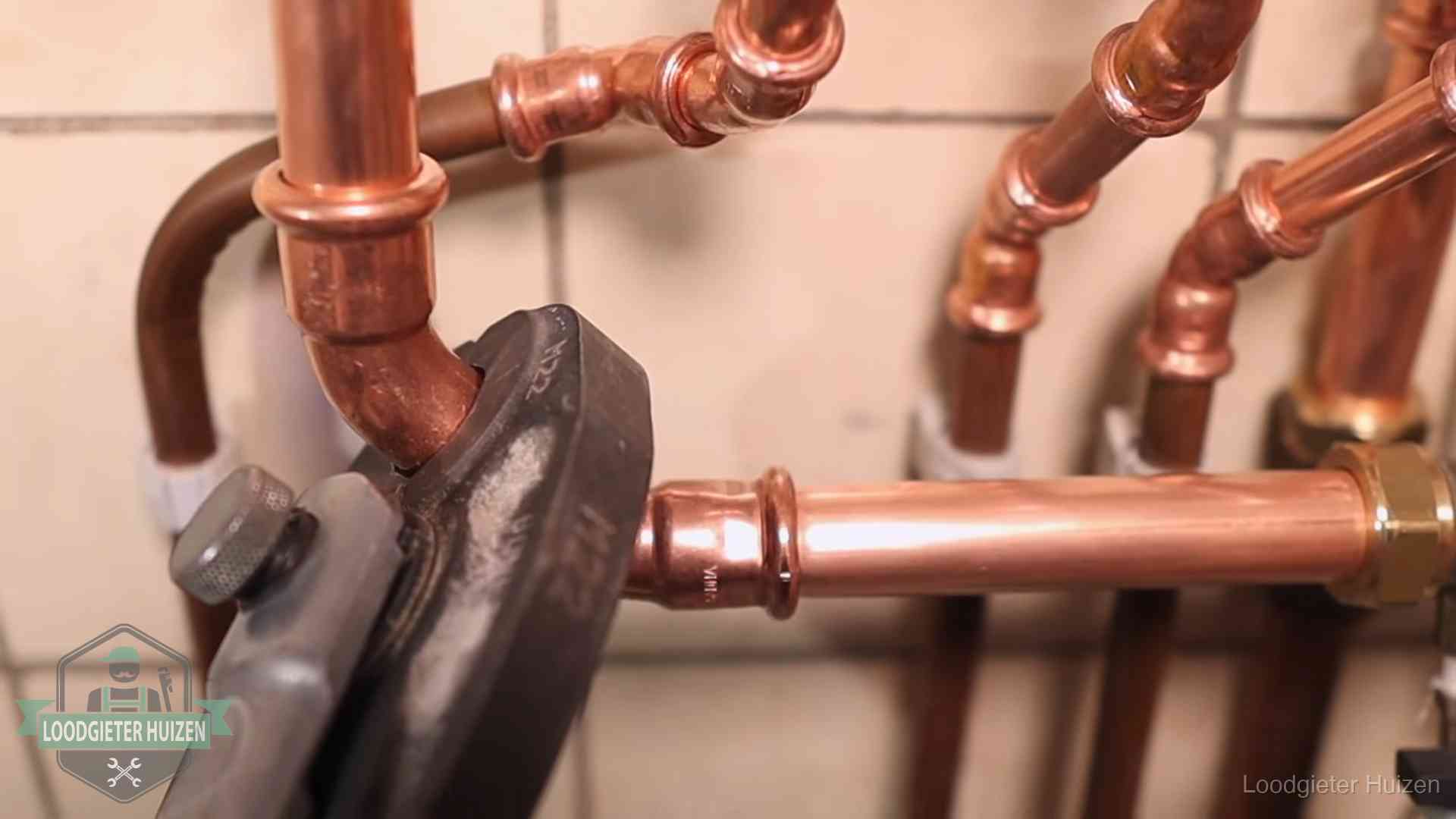 Werkwijze van ons loodgietersbedrijf in Huizen Persmachine perst een koperen fitting op nieuw leidingwerk in Huizen