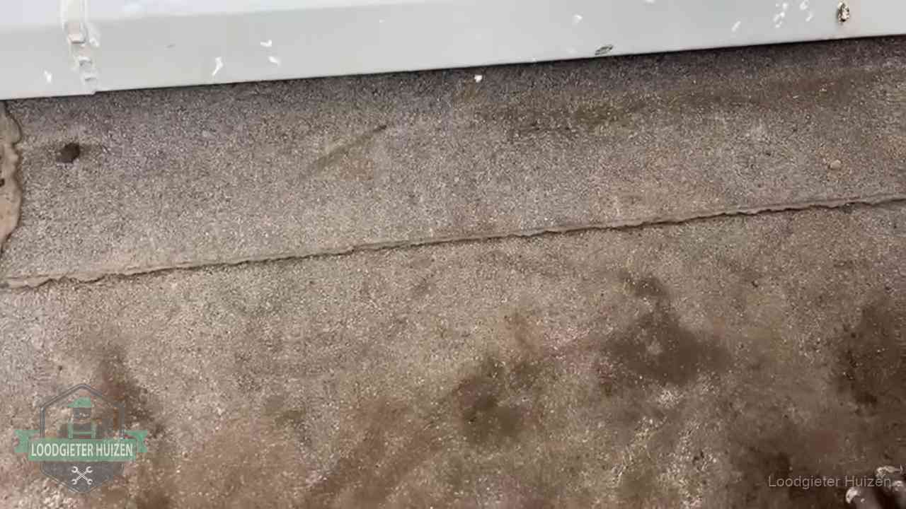 Stormschade en neerslag op daken in Huizen Vochtplekken bij de naad van een plat dak na aanhoudende regen in Huizen
