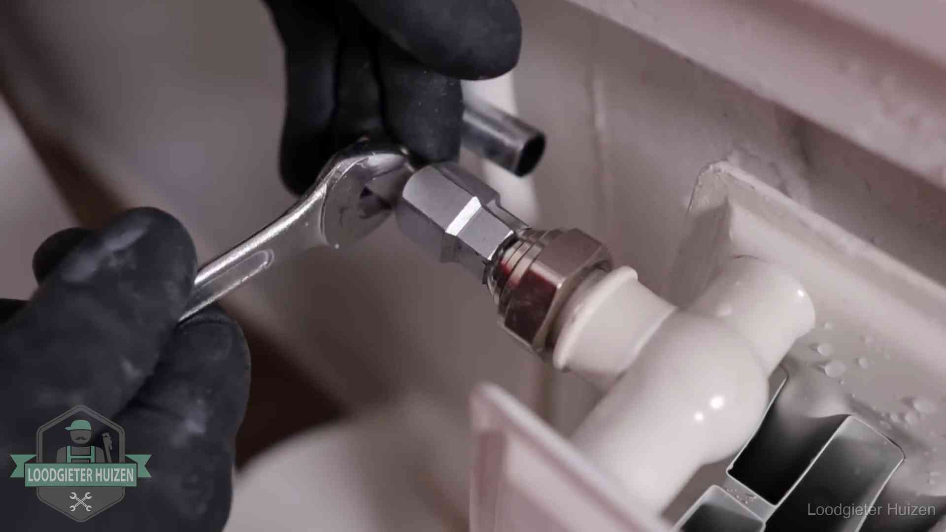 Radiatoren en waterzijdig inregelen in Huizen Steeksleutel draait een wartelkoppeling op een radiatorkraan aan in Huizen