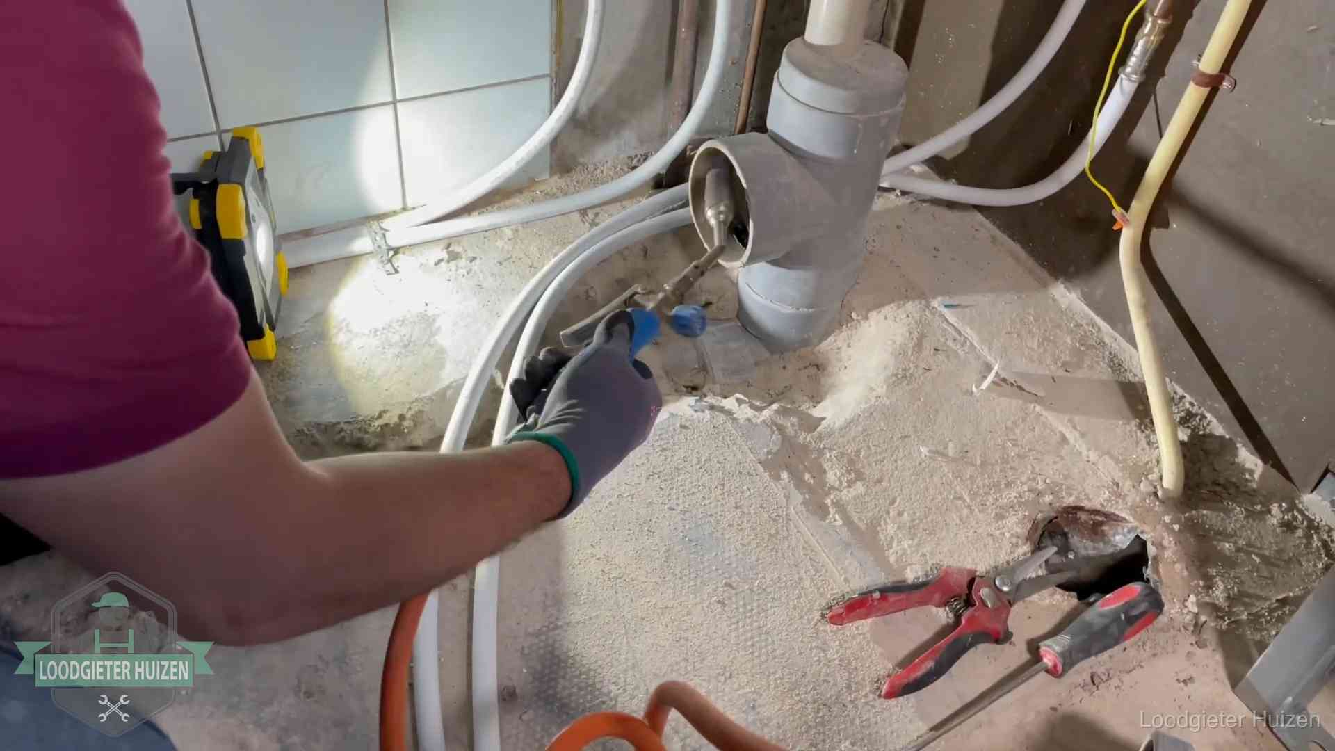 Standleiding en gedeelde leidingen in Huizen Loodgieter werkt aan leidingen bij een pvc-standleiding in een appartement in Huizen