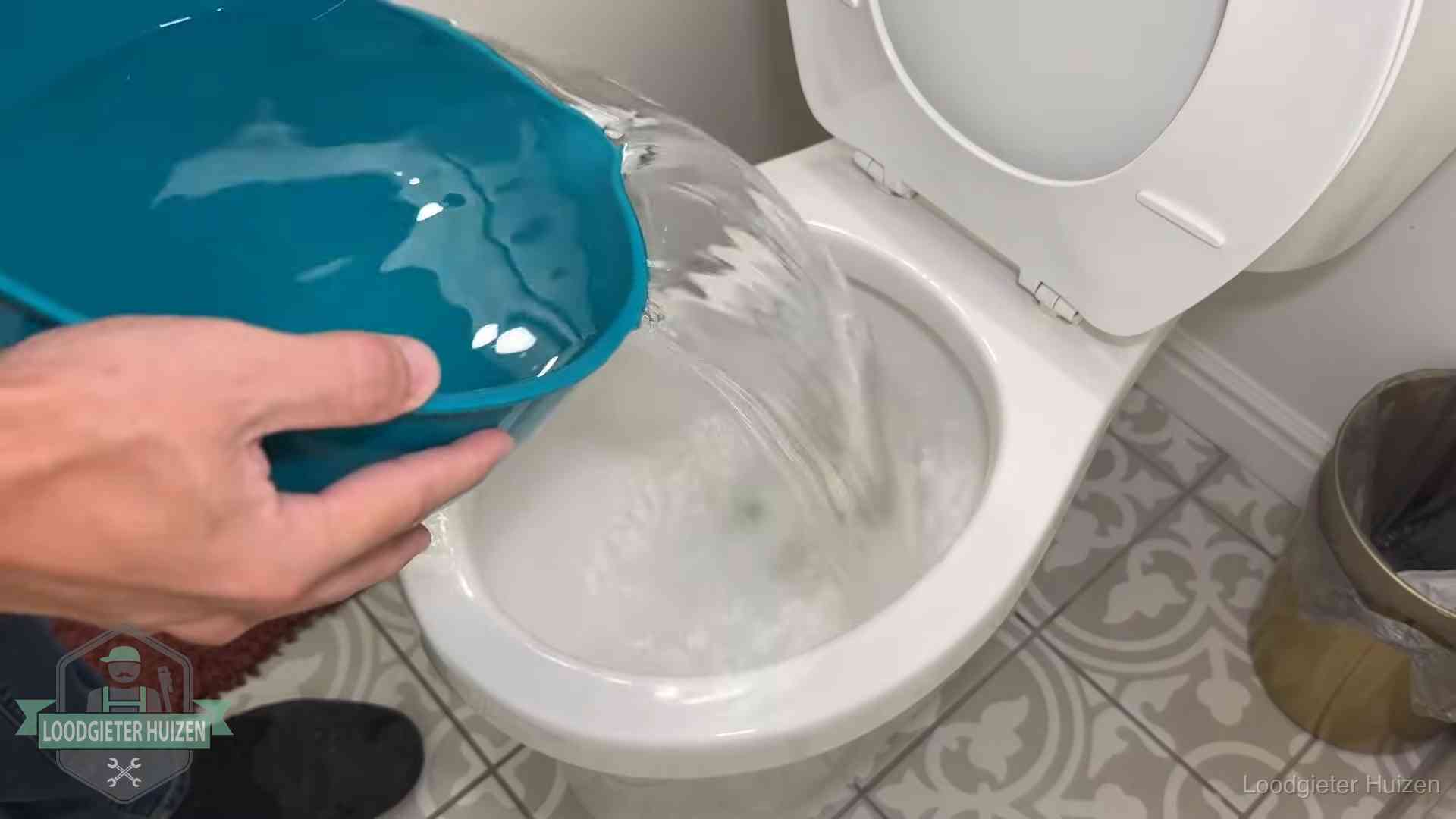 De warm-water-methode in Huizen Warm water wordt voorzichtig in de wc-pot gegoten in Huizen