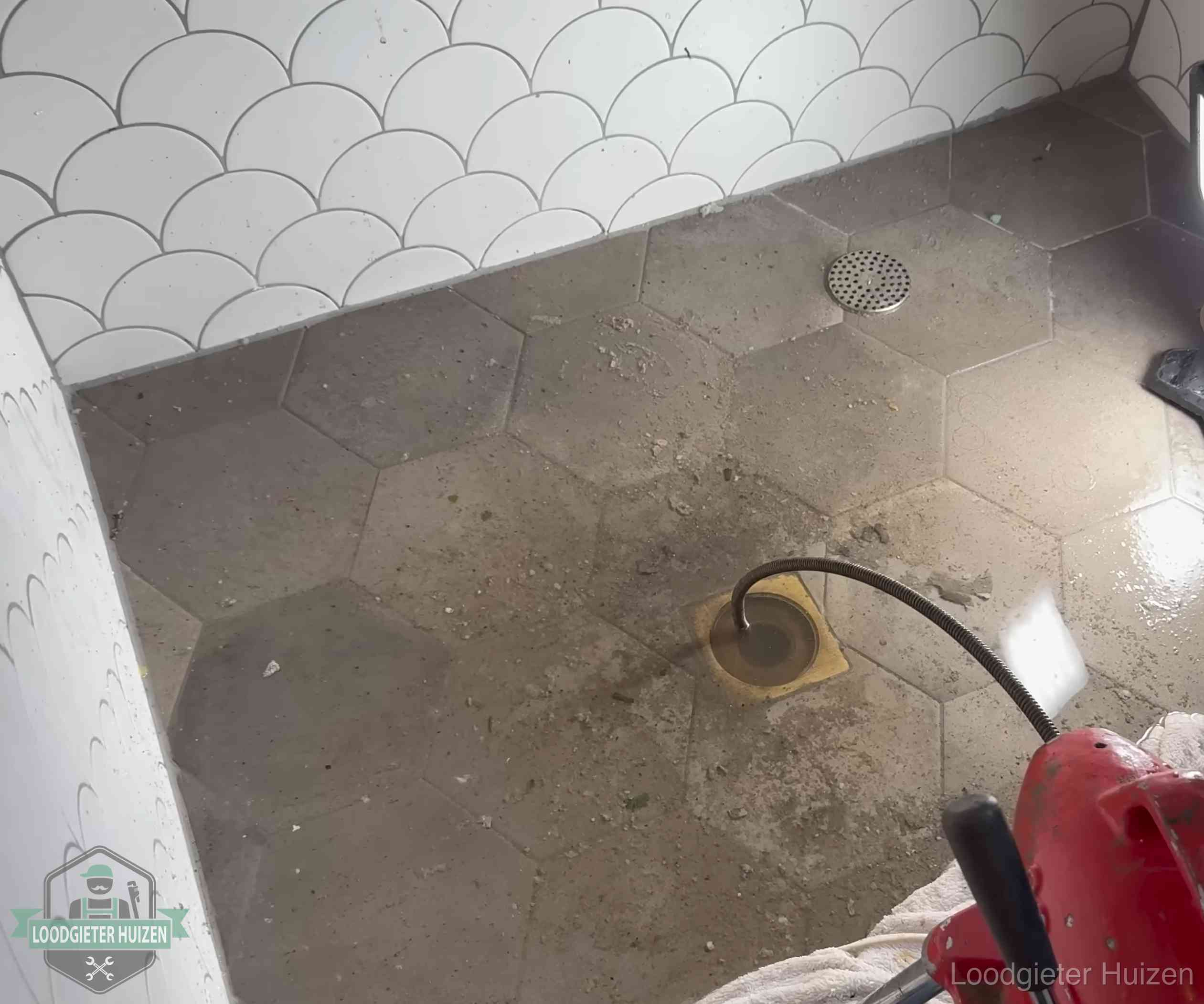 Stank uit wc of vloerput in Huizen Vloerput met waterslot in een badkamer in Huizen, een bron van stank als het waterslot droogstaat
