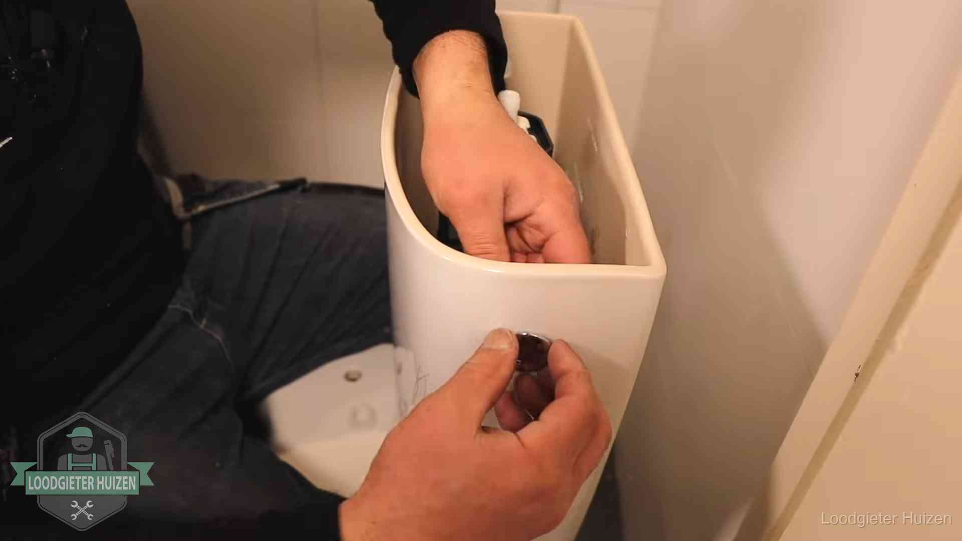 Je wc verstoppingsvrij houden in Huizen Drukknop van een duoblok-stortbak wordt gemonteerd bij een toilet in Huizen