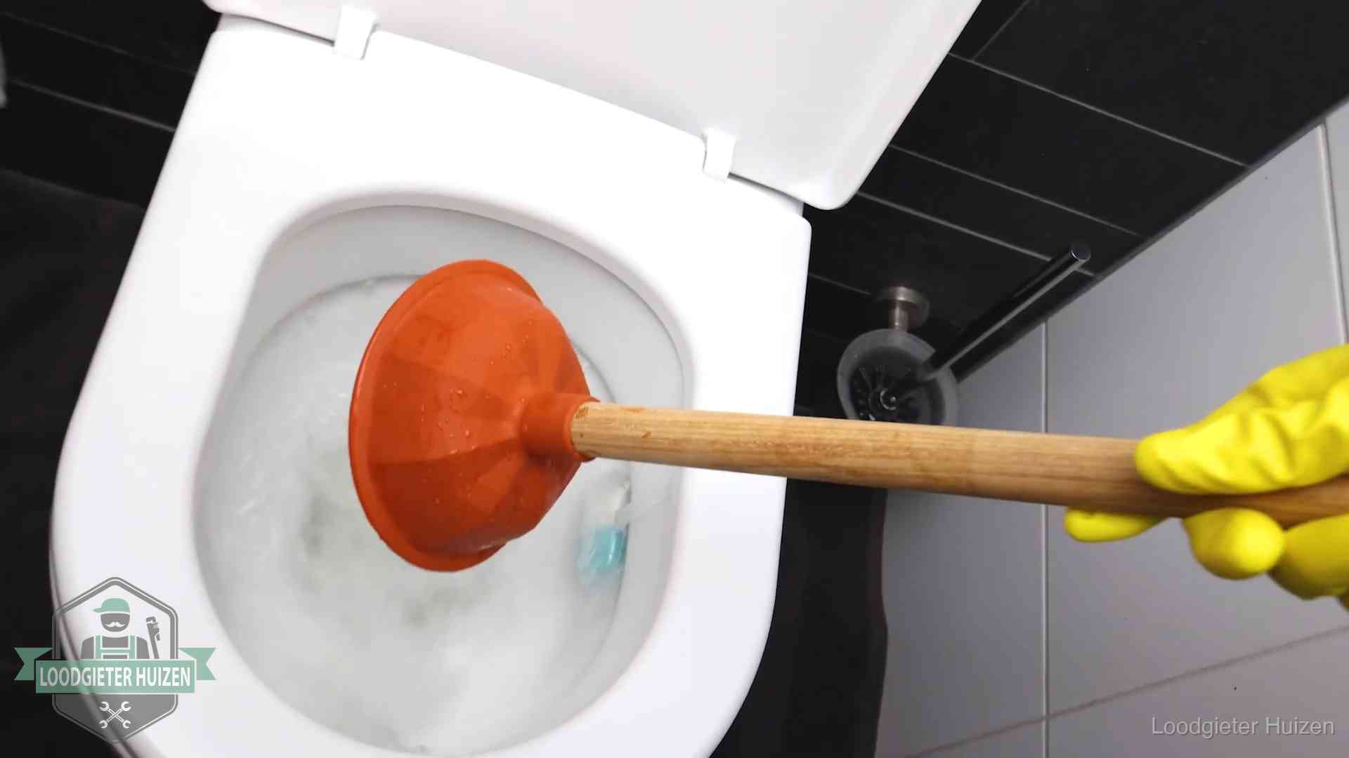 Wc ontstoppen met de plopper in Huizen Plopper wordt in de wc-pot gedrukt bij het ontstoppen van een toilet in Huizen